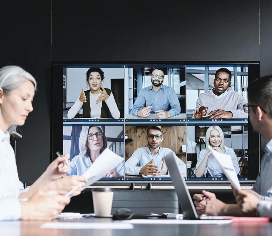 People at a conference table on a video call