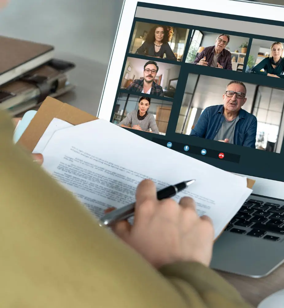 Someone in dark yellow sits at their laptop on a video call with 6 participants.